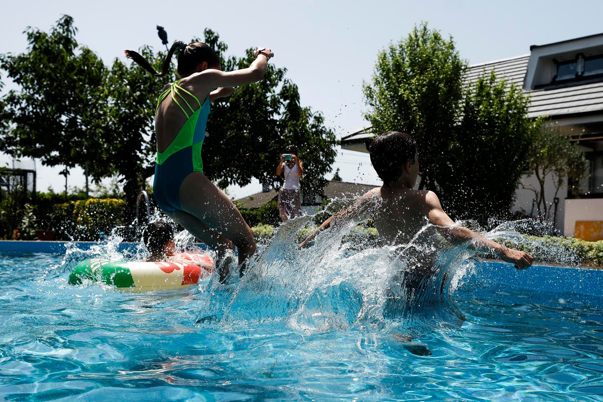 FOTODELDÍA - BERANGO (BIZKAIA), 21/06/2026.- Tres jóvenes se refrescan en una piscina en Berango (Bizkaia) este domingo, jornada en la que el Departamento vasco de Seguridad ha elevado la alerta a roja por la ola de calor al esperarse temperaturas muy altas que alcancen los 40 grados.  EFE/Miguel Toña
