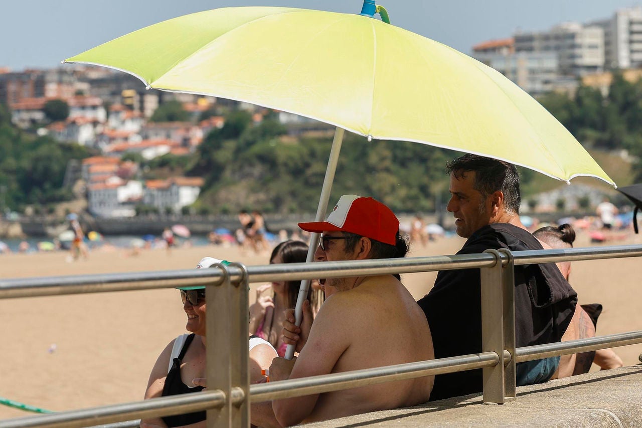 GETXO (BIZKAIA), 21/06/2026.- Varias personas se resguardan del sol en la playa de Ereaga en Getxo (Bizkaia) este domingo, jornada en la que el Departamento vasco de Seguridad ha elevado la alerta a roja por la ola de calor al esperarse temperaturas muy altas que alcancen los 40 grados.  EFE/ Miguel Toña
