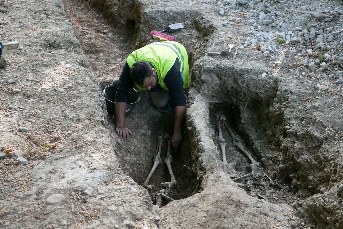 Un operario junto a dos de los enterramientos medievales de la calle Bosquecillo