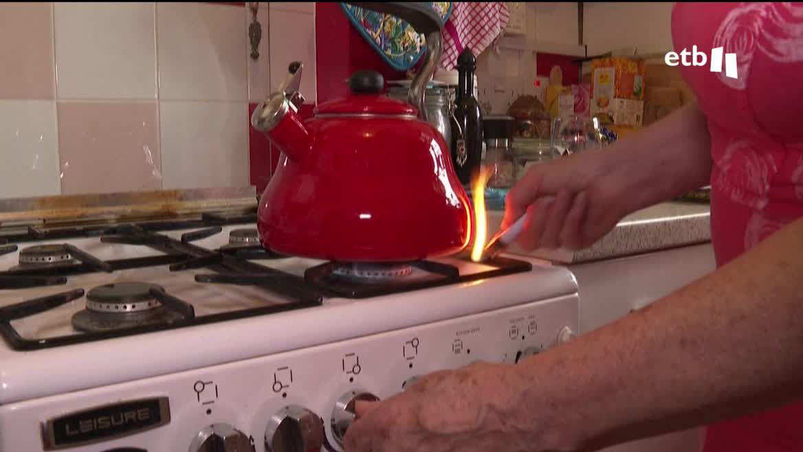 Una mujer encendiendo la cocina.