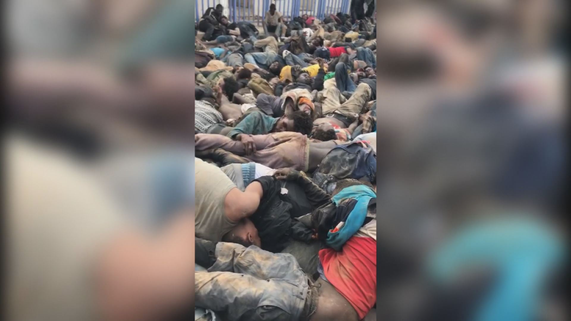 Migratzaileak lurrean pilatuta. Agentzietako bideo batetik ateratako irudia.