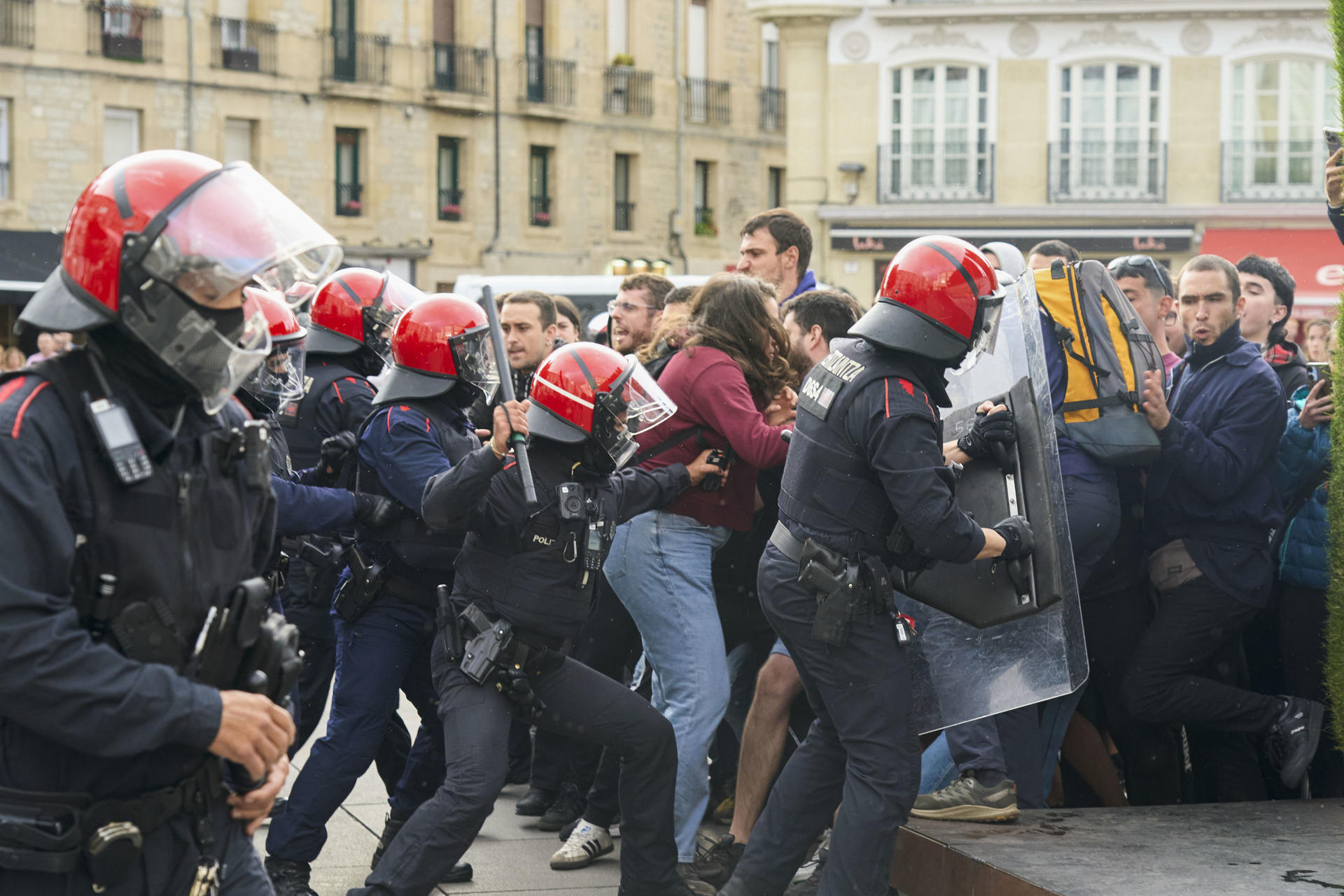 VIORIA, 23/07/2025.- Miembros de la Ertzaintza cargan ante las protestas de los participantes en la acampada situada hoy miércoles en la plaza de la Virgen Blanca de Vitoria, para denunciar el veto político en las Txosnas de Gasteiz. EFE / L. Rico.

