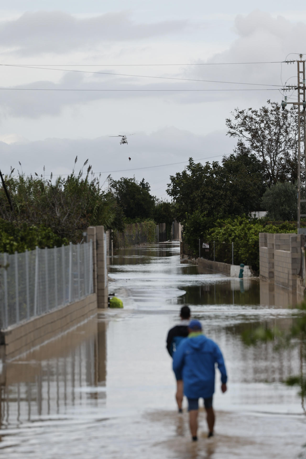 VALENCIA, 19/10/2026.- Un helicóptero realiza en las labores de rescate de una persona en Oliva (Comunidad Valenciana) este lunes. El episodio de lluvias y tormentas que afecta a la Comunidad Valenciana ha dejado tres víctimas mortales y numerosos rescates de personas atrapadas en coches, viviendas y tejados, y ha obligado a confinar temporalmente hasta 145 municipios en las provincias de Valencia y Alicante, aunque la cifra se ha reducido después a ocho. EFE/ Manuel Bruque
